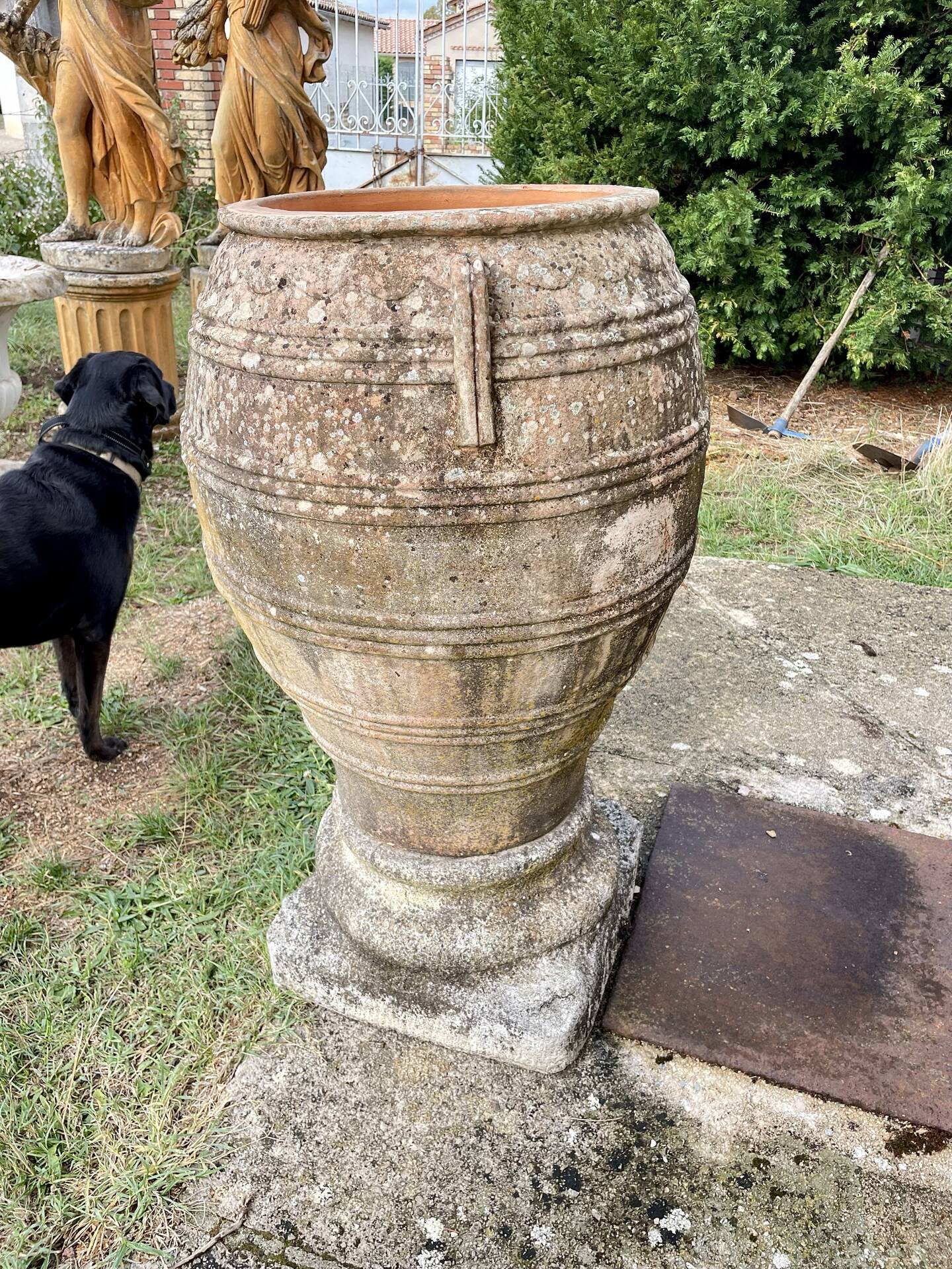 Large Cretan jar in terracotta with three handles on a stone base.