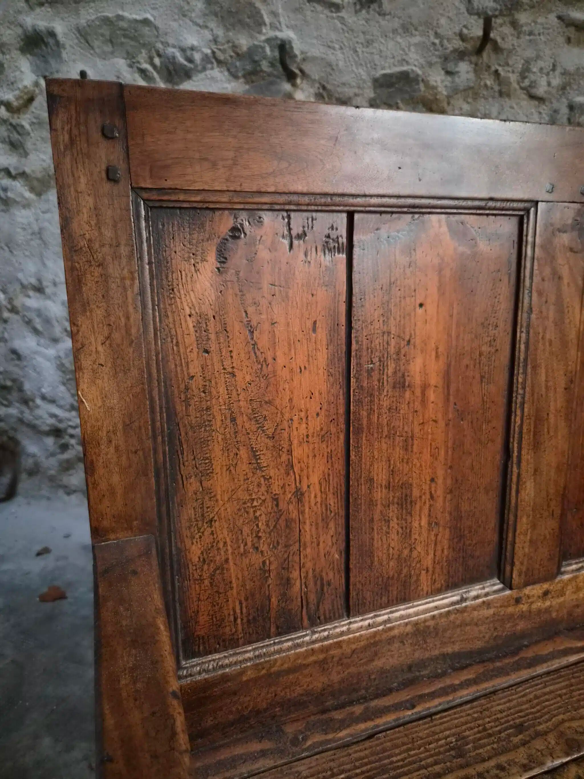 Rustic French antique storage bench from the 18th century in walnut and pine.
