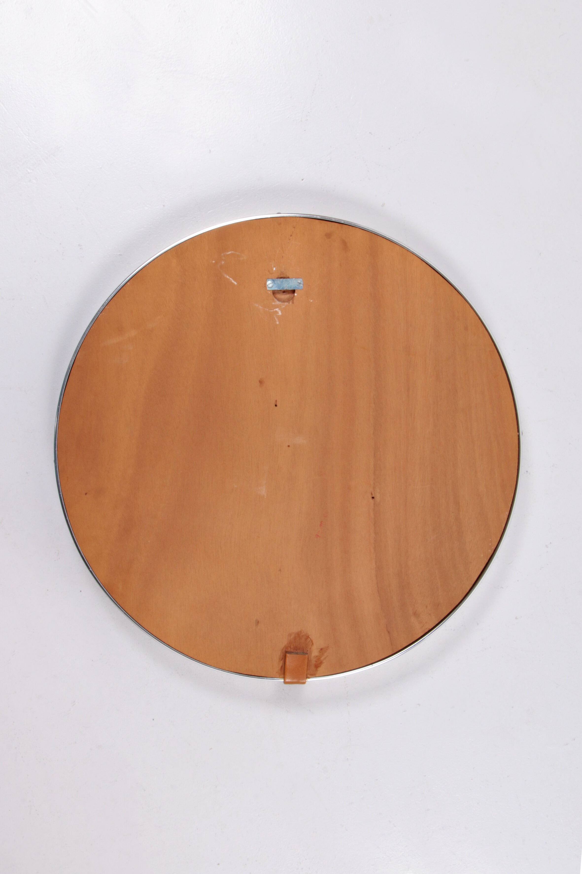 Round mirror covered with leather and chrome, made in France in the 1970s.