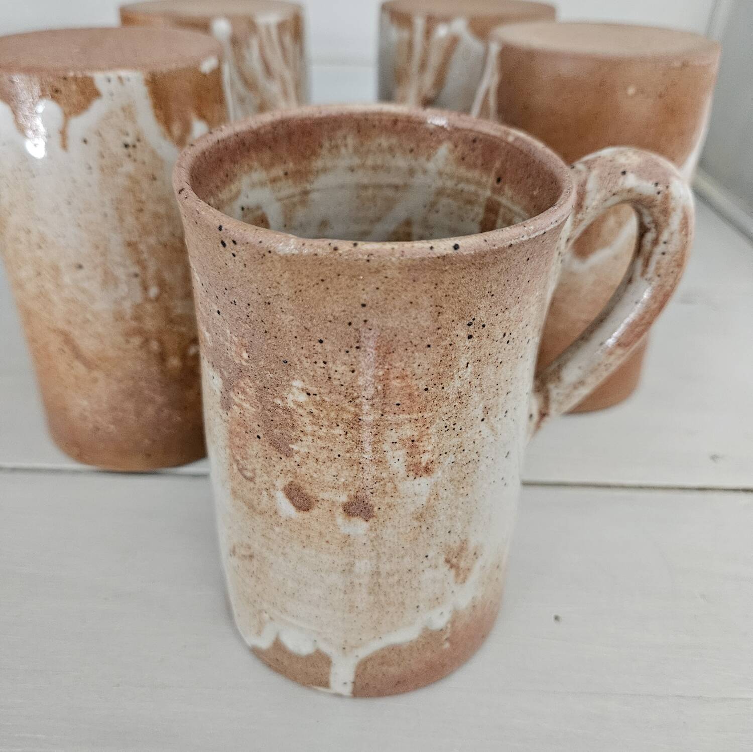 Set of 5 vintage handcrafted stoneware mugs in beige, pink, and white glazed stoneware