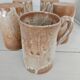 Set of 5 vintage handcrafted stoneware mugs in beige, pink, and white glazed stoneware