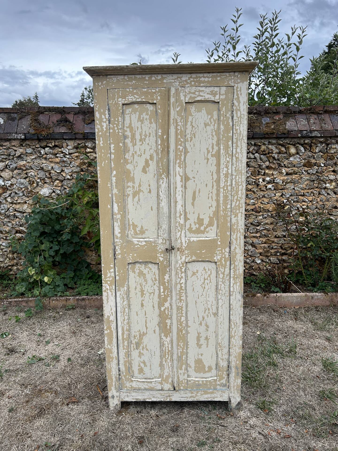Small antique wardrobe with a faded white patina.