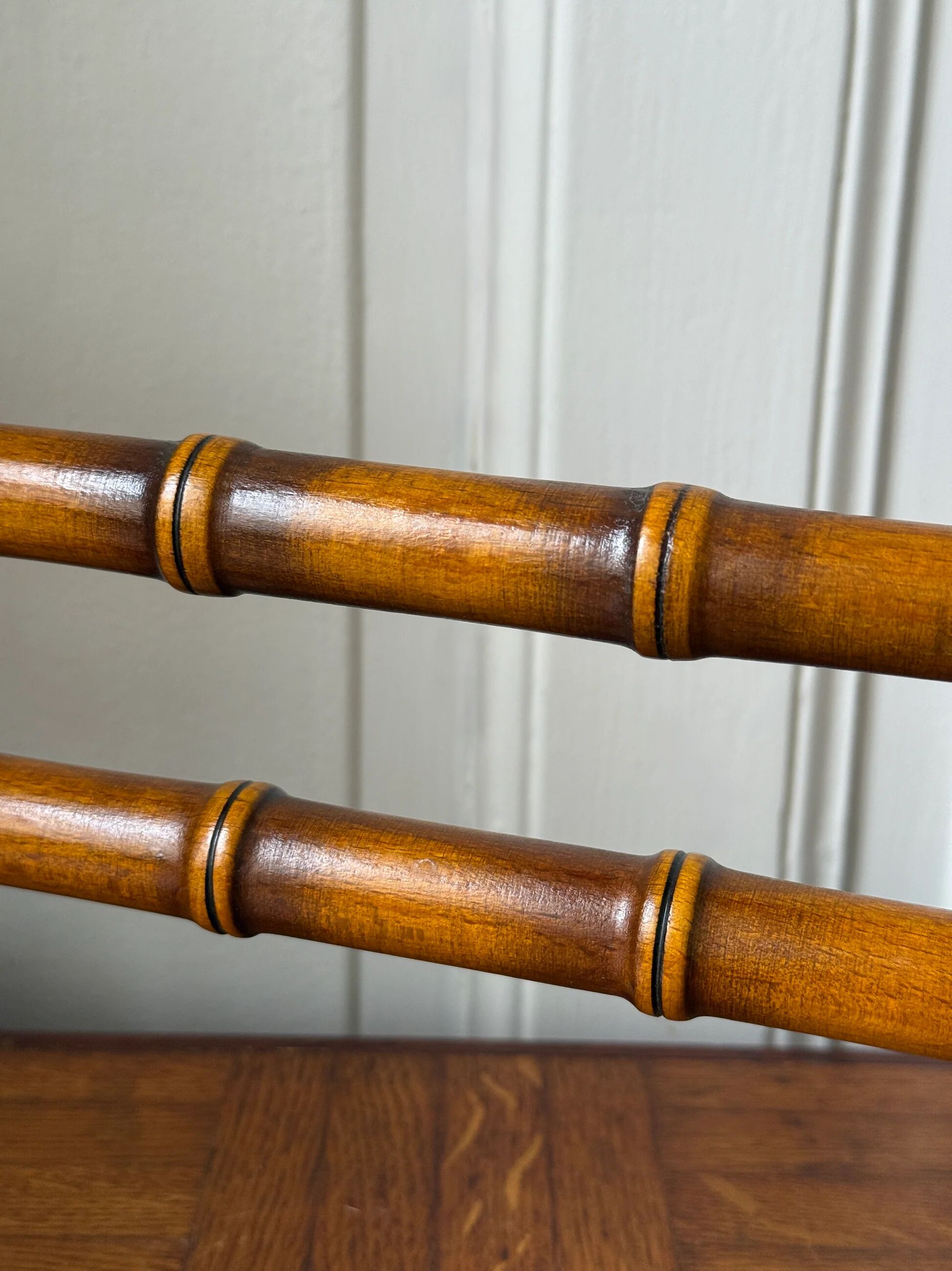 Wall-mounted coat rack made of turned wood in a bamboo style.