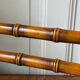 Wall-mounted coat rack made of turned wood in a bamboo style.