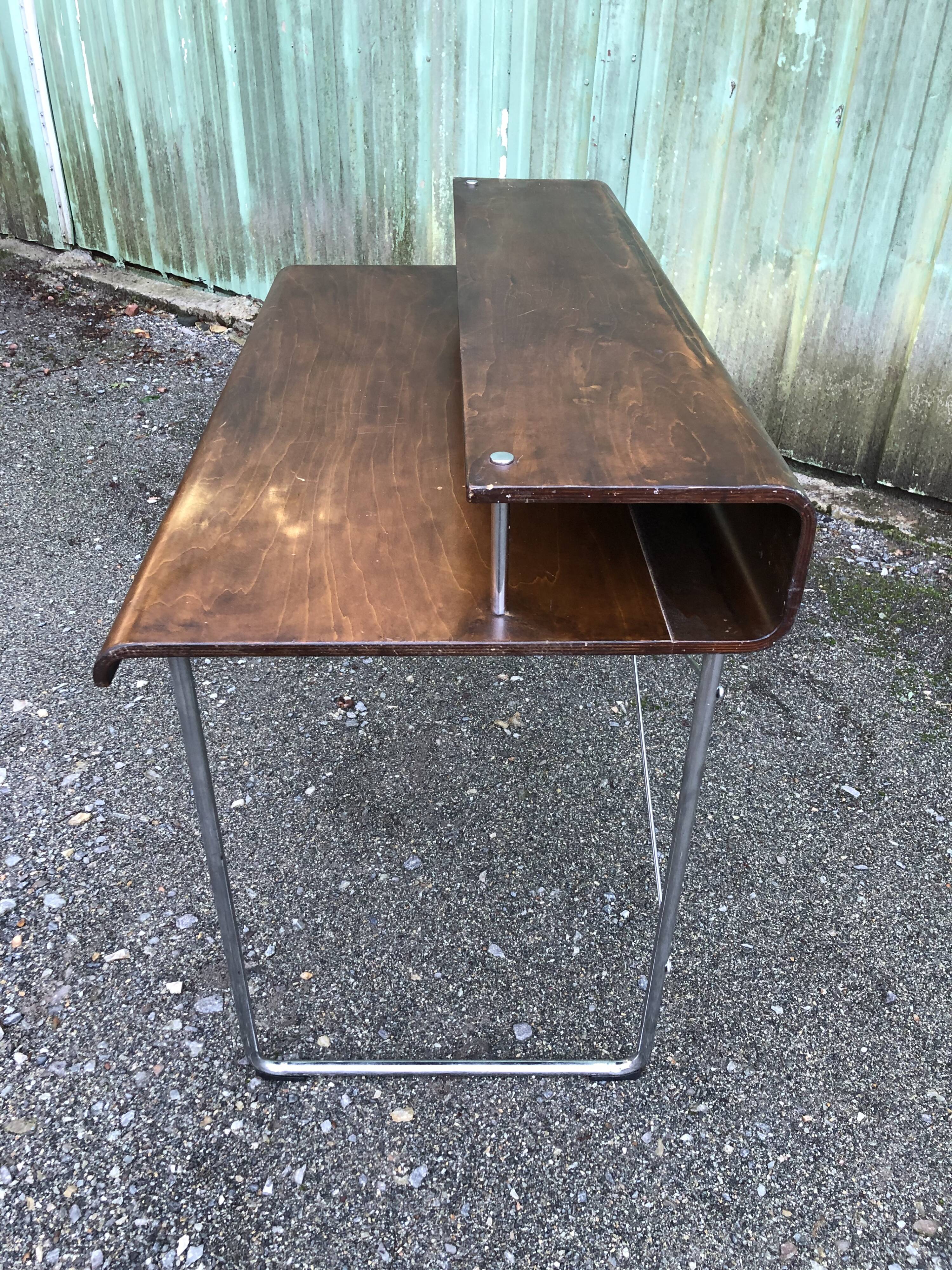 Design desk in formed glued laminated wood with chrome tubular base.
