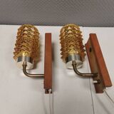 A set of wall lamps in teak wood, with amber colored glass