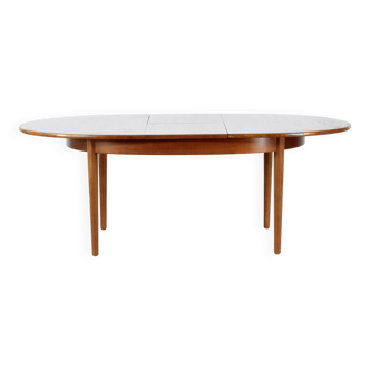 A stylish vintage teak danish influenced extending dining table for sale.  Supported on four slender