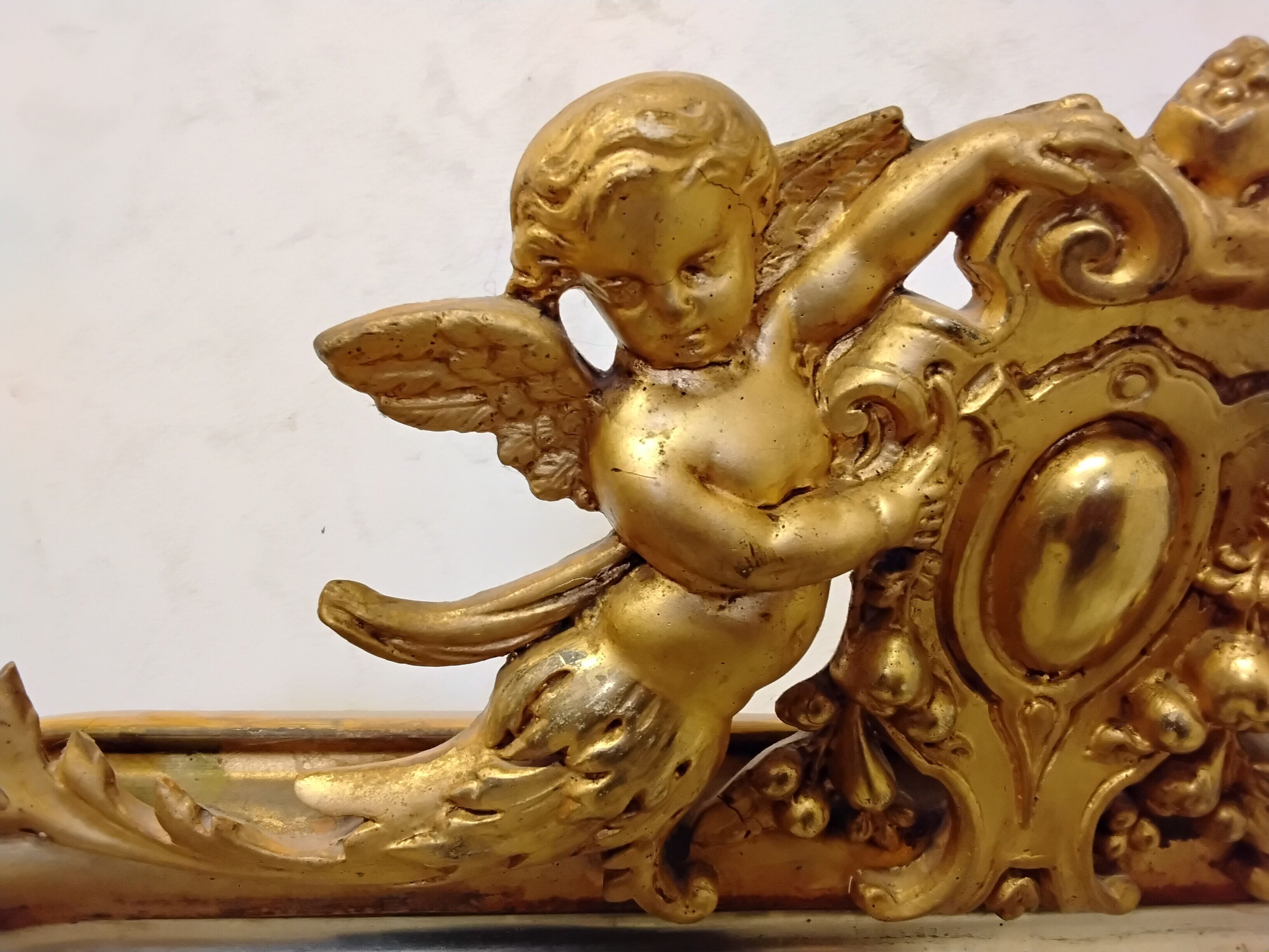 Antique mirror with a gilded frame and cherubs.