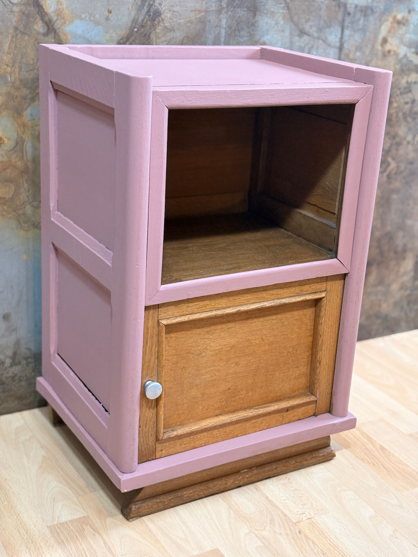 Pink bedside table with haberdashery and raw wood.