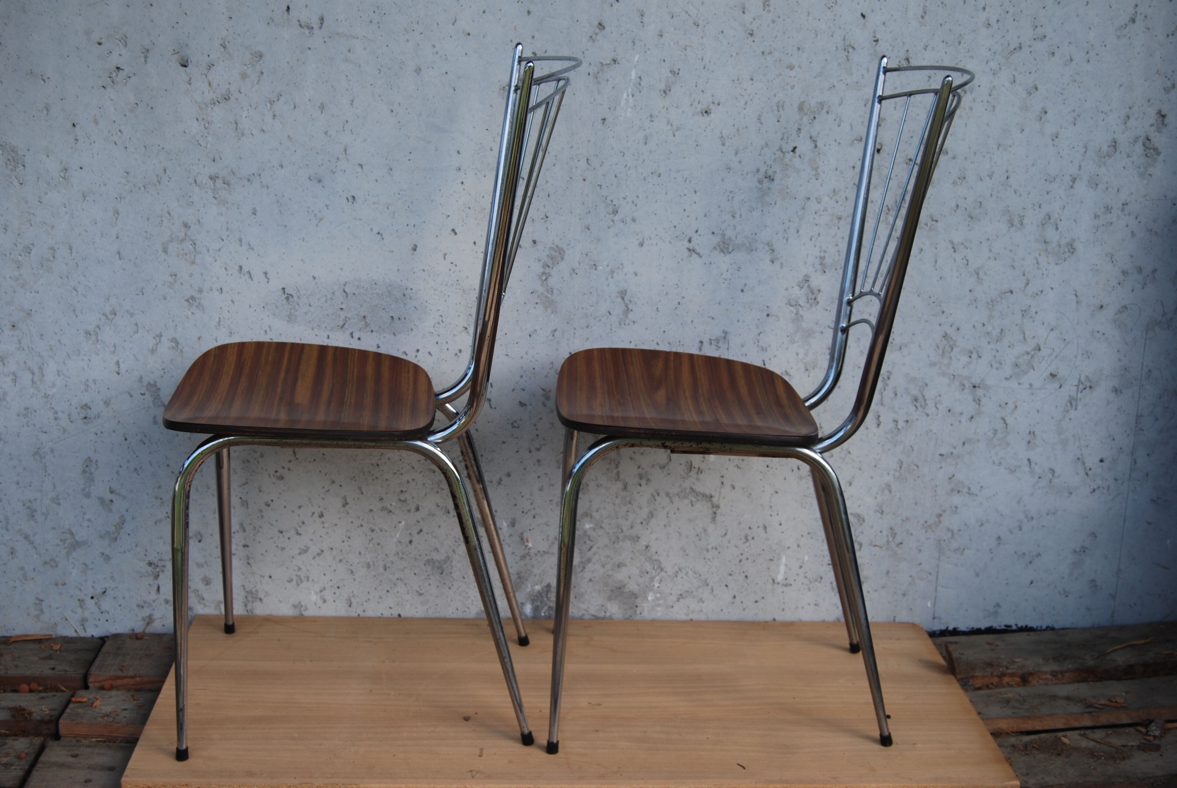 Pair of formica chairs with chrome metal backs in the shape of a lyre.