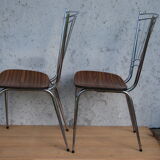 Pair of formica chairs with chrome metal backs in the shape of a lyre.