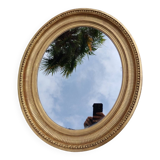 Antique oval mirror in gilded stucco with gold leaf, 19th century