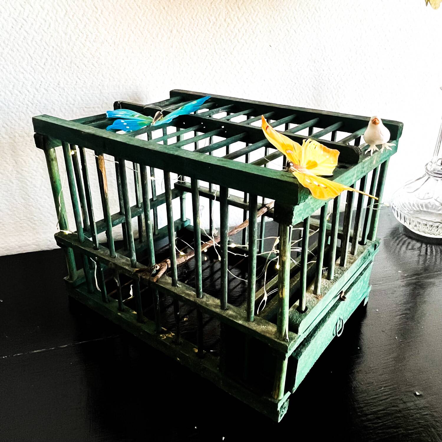 old bird cage made of wood and painted green