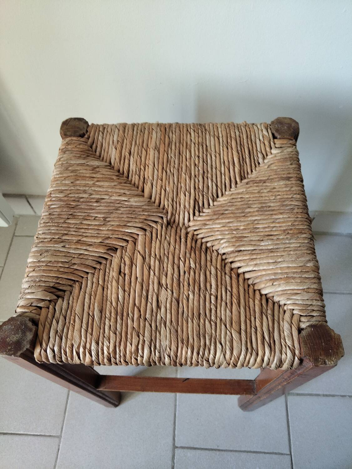 Antique campaign stool in solid wood with a straw seat.