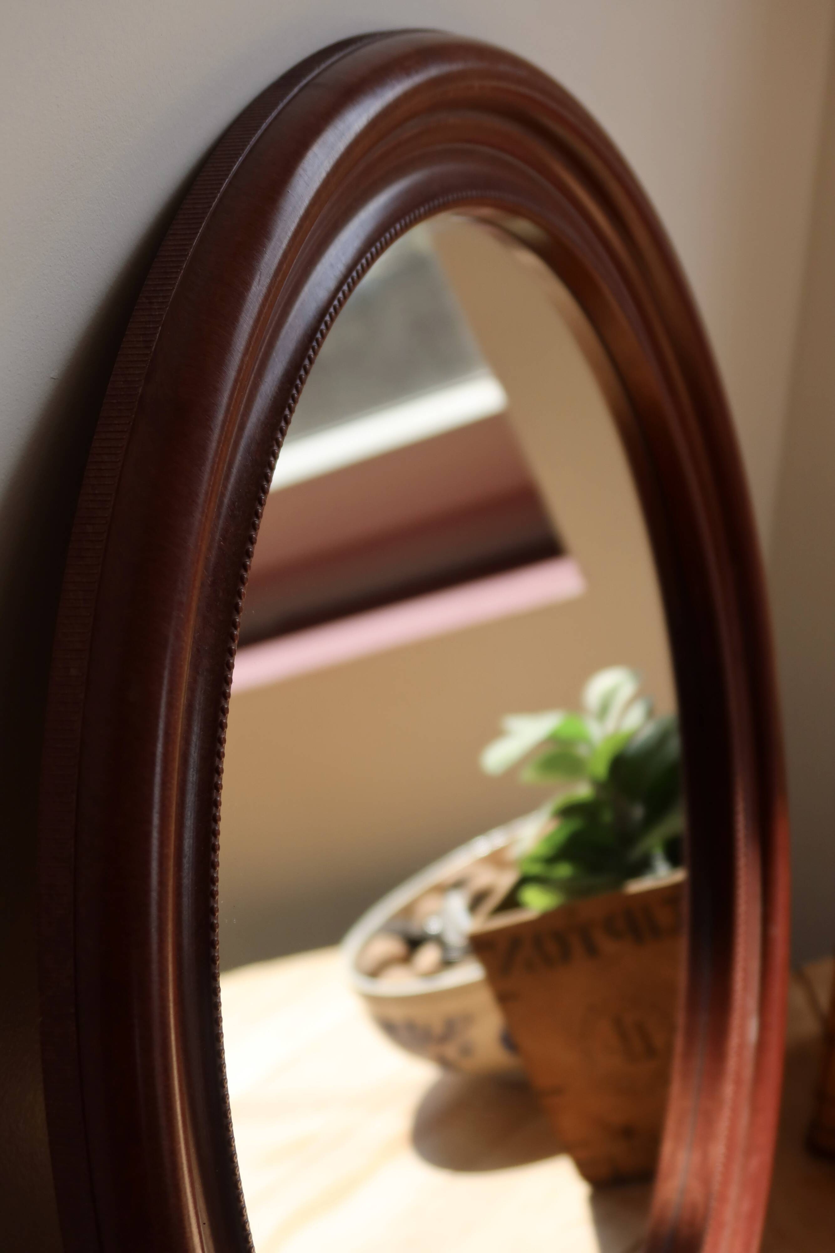 Round vintage mirror with mahogany wood effect frame.