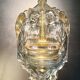 Old wall-mounted holy water font in moulded glass decorated with angels.