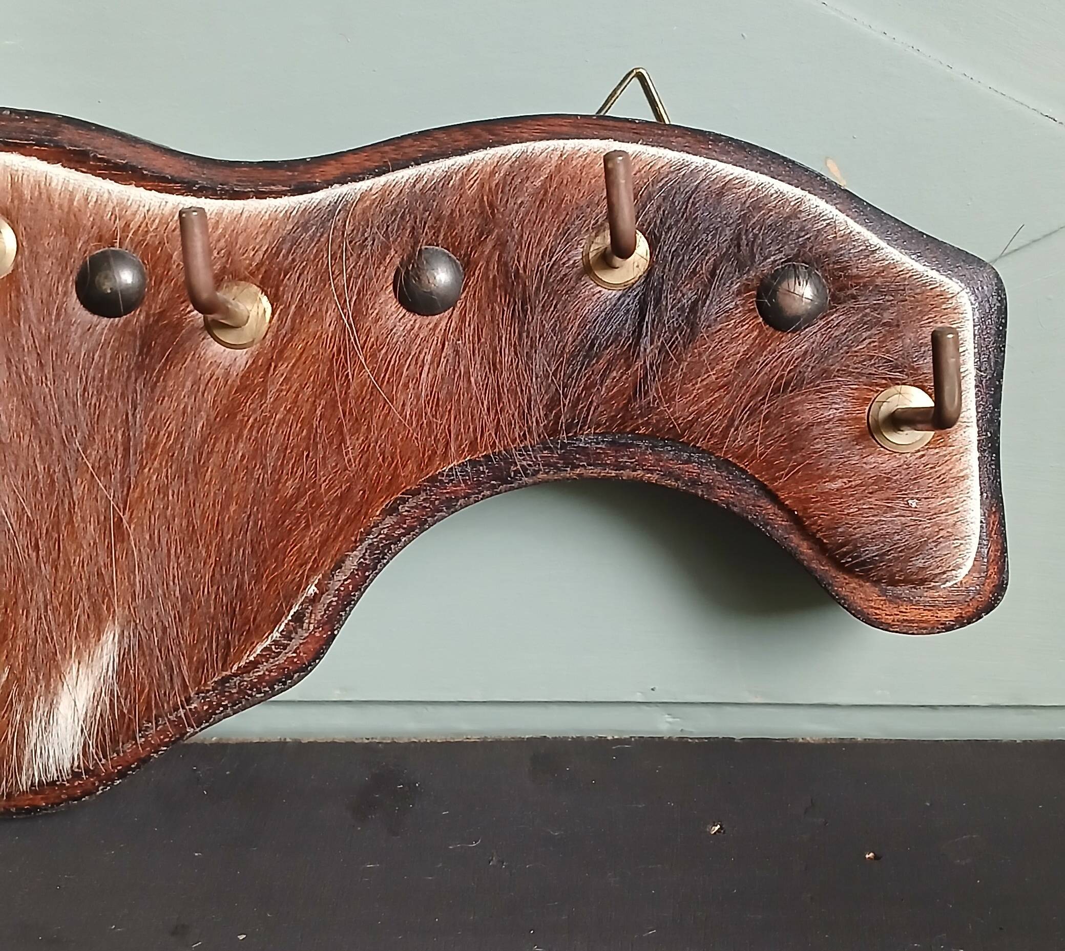 Wooden coat rack, nails & cowhide