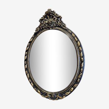 Old black and gold patinated oval mirror louis xv style