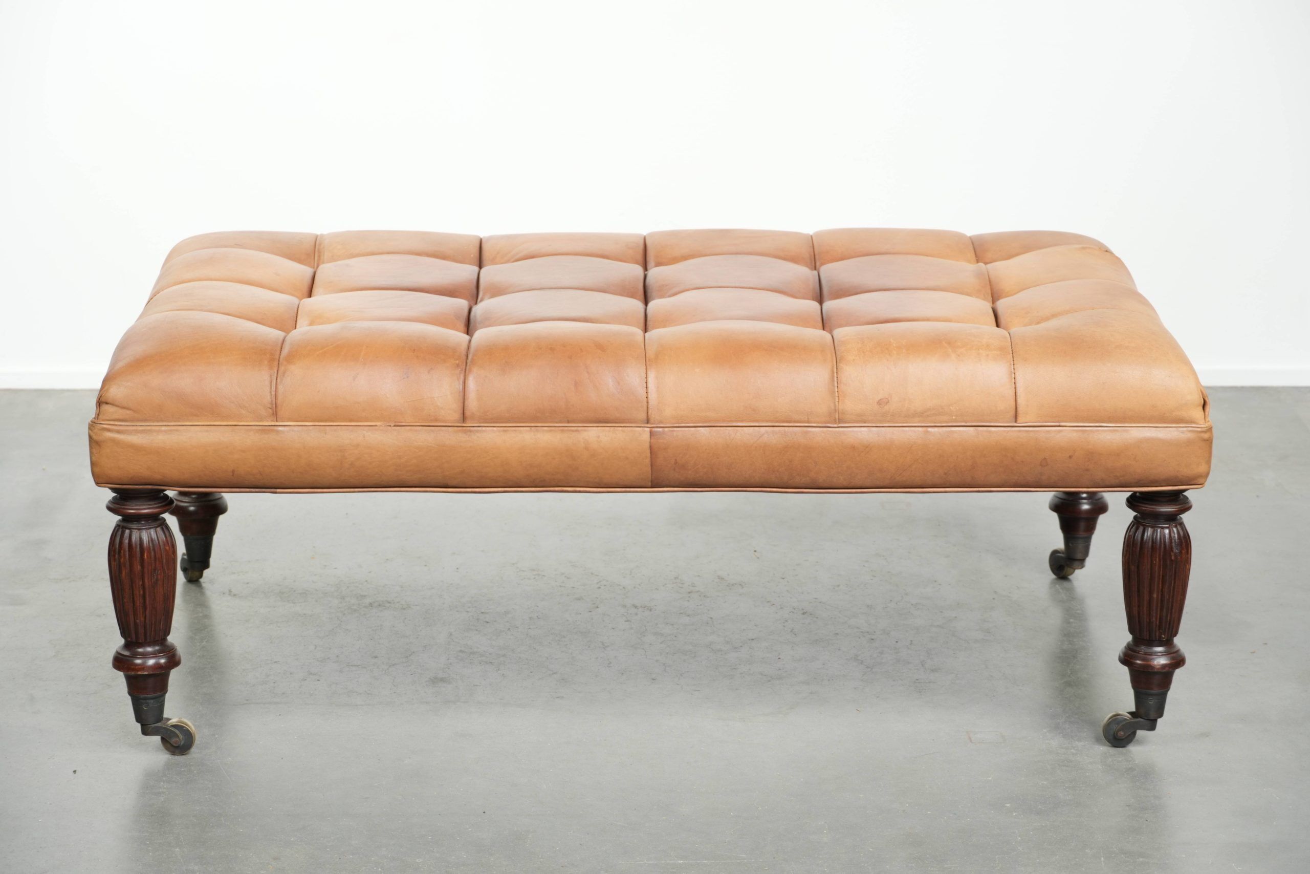 Sheepskin ottoman/coffee table on wheels in English chesterfield style