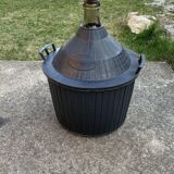 Dame-Jeanne vintage in olive green glass with a basket and black plastic lid.