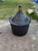 Dame-Jeanne vintage in olive green glass with a basket and black plastic lid.