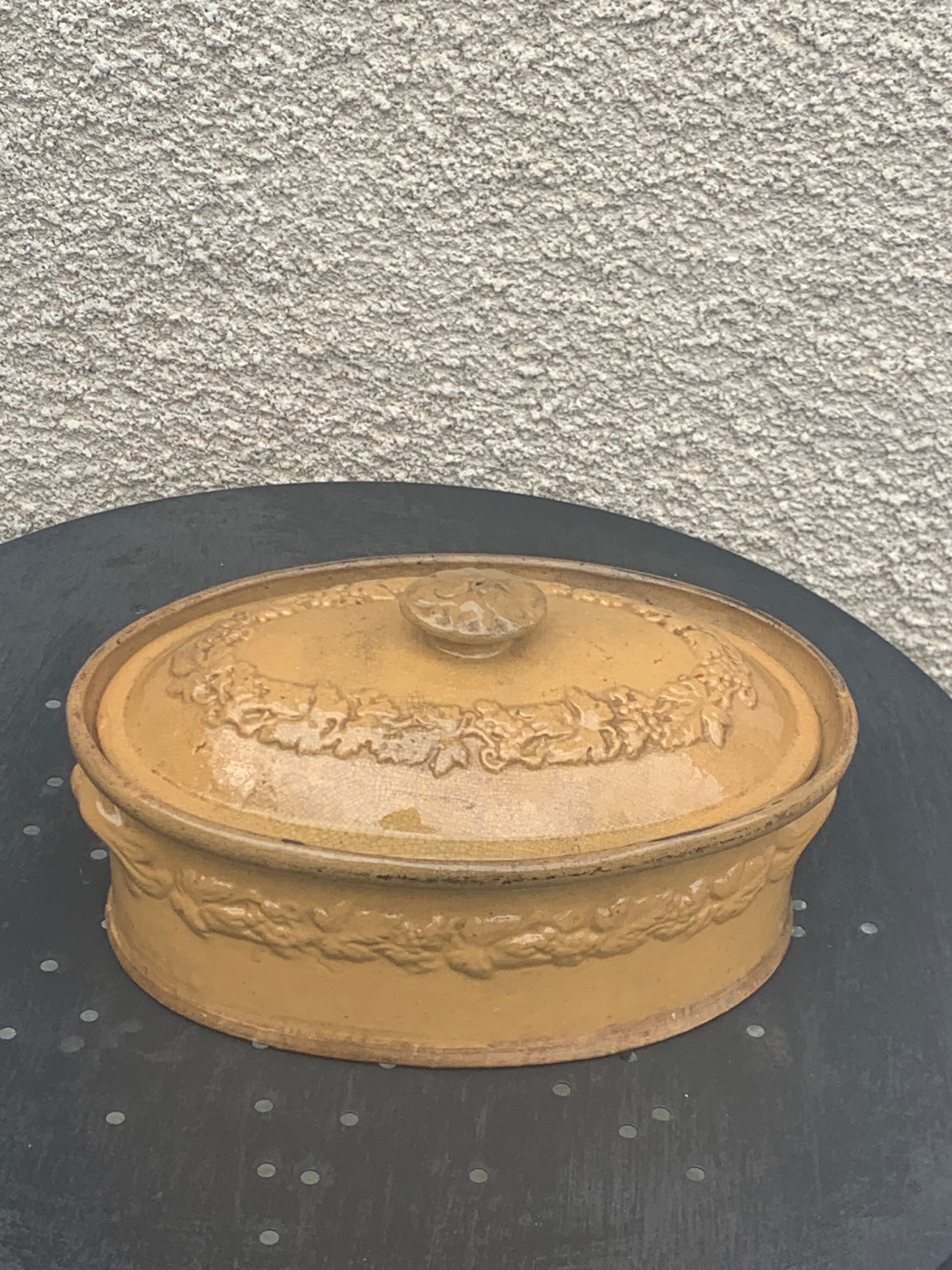 Old terrine in glazed stoneware and floral decoration mustard yellow slip