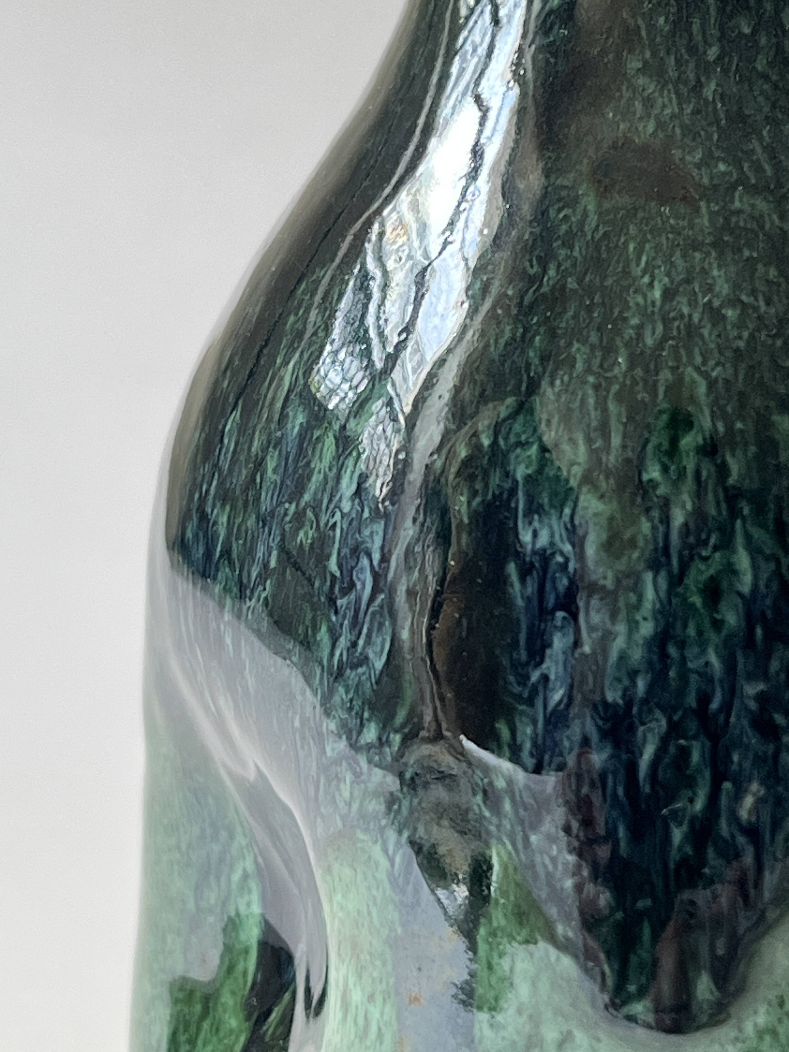 Ceramic vase with a glazed blue/green finish.