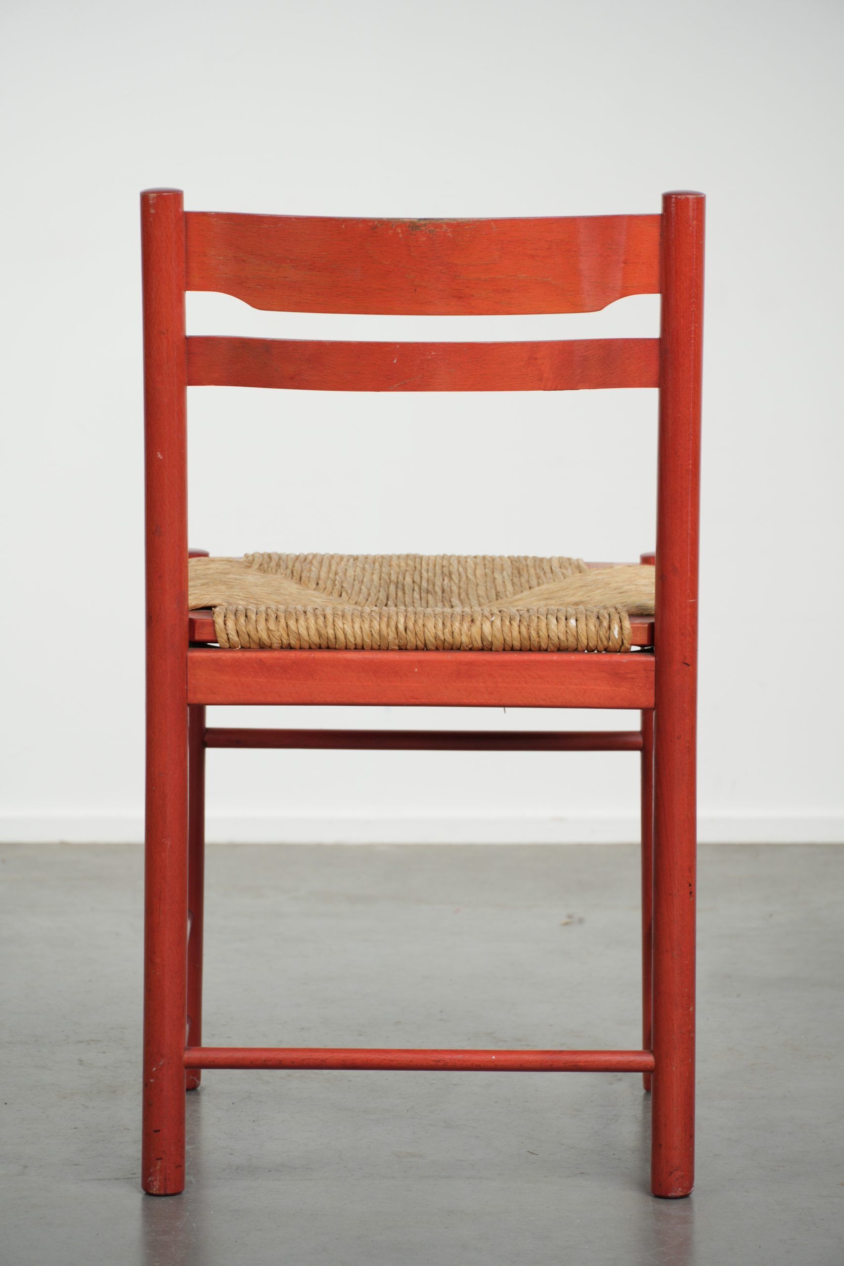 Red vintage wooden chair from the 1970s with a woven wicker seat