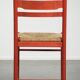 Red vintage wooden chair from the 1970s with a woven wicker seat