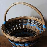 Vintage wooden basket with round handle, blue and black weaving.