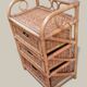 Small storage unit / freestanding shelf in light rattan.