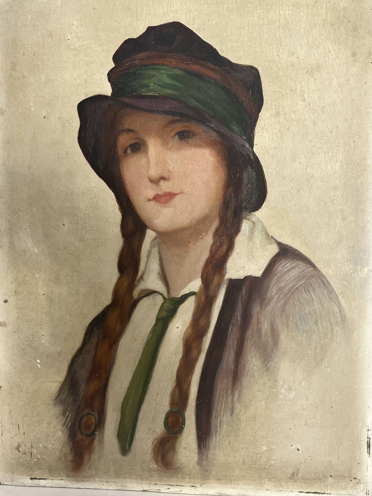 Old portrait of a young woman with braids and a hat, circa 1930
