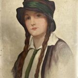 Old portrait of a young woman with braids and a hat, circa 1930