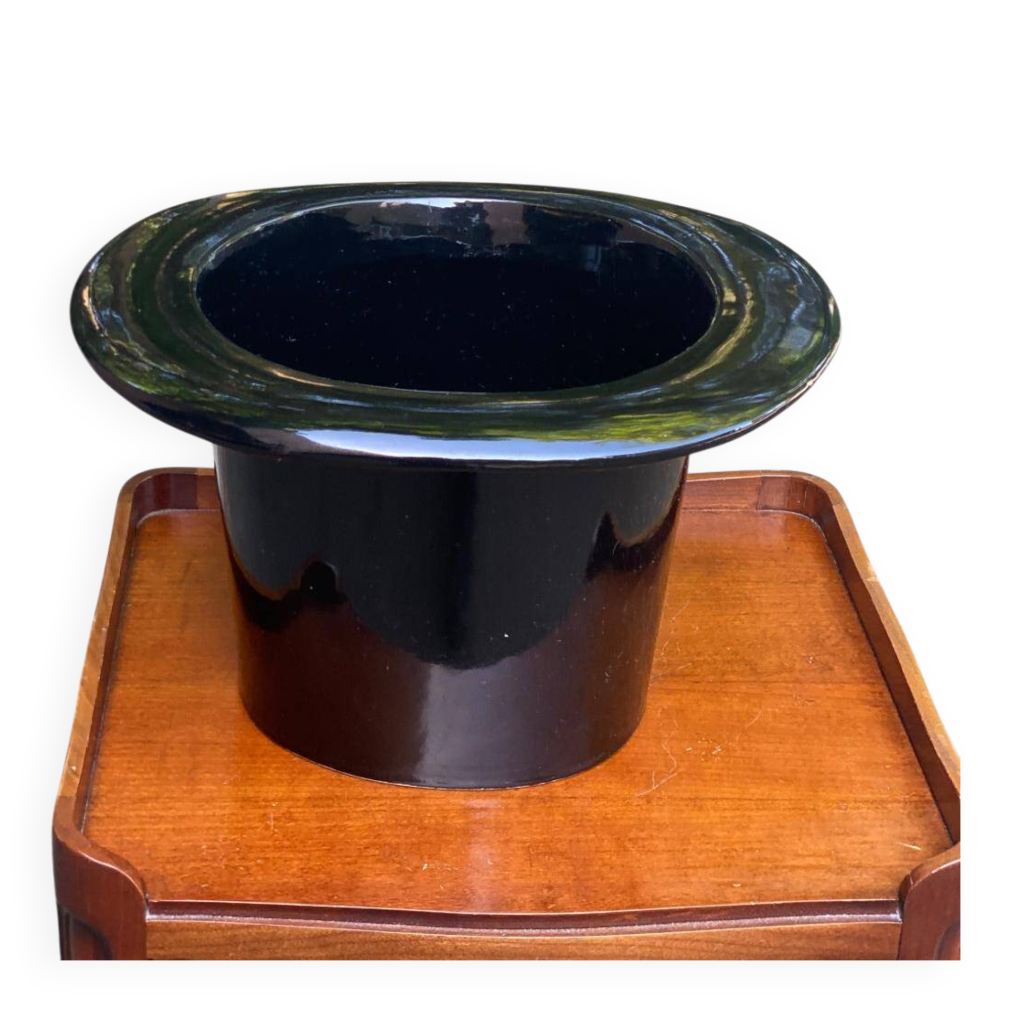 A black top hat-shaped vale turned upside down from the 1960s.