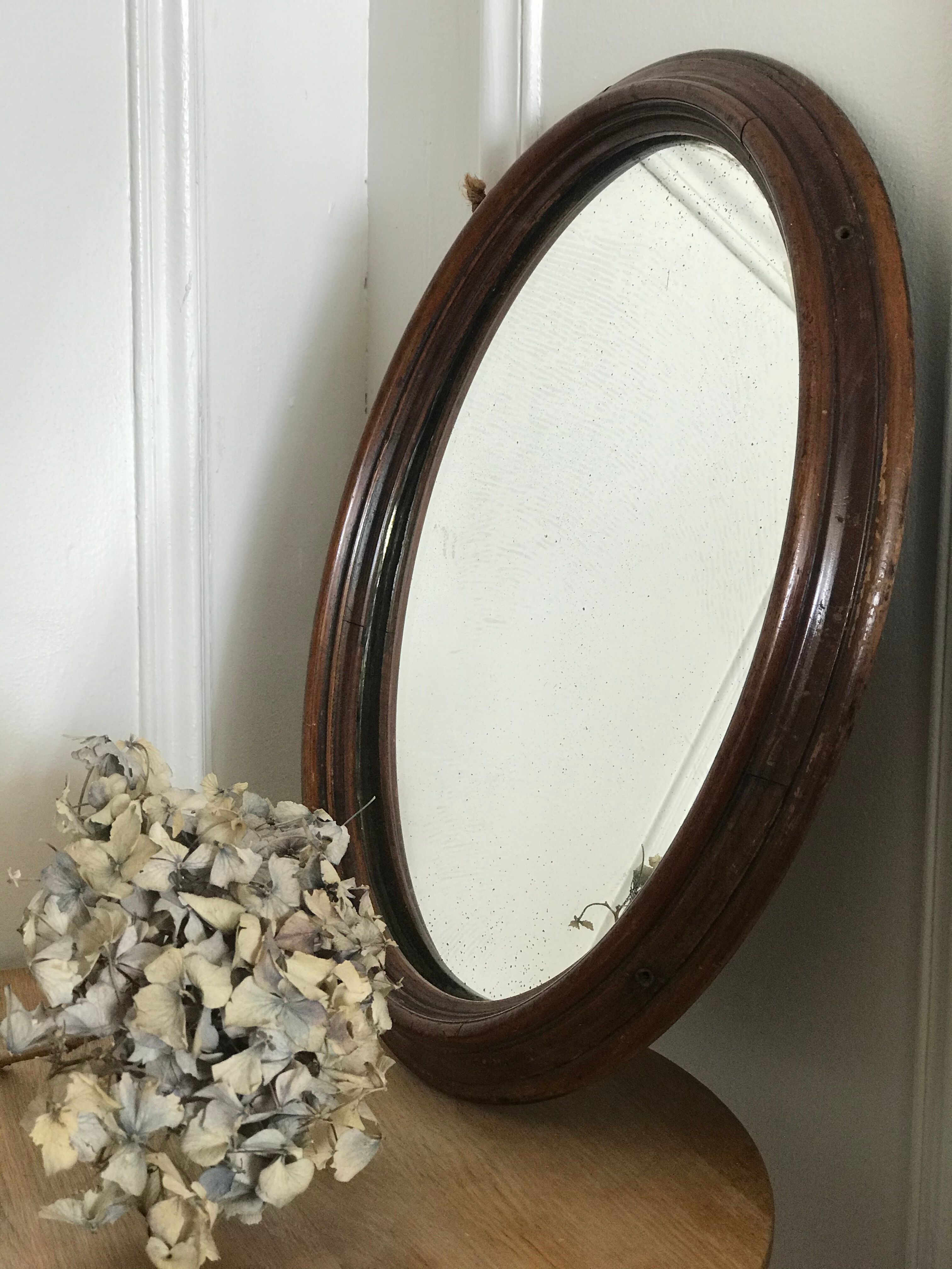 Old oval mirror with wooden frame