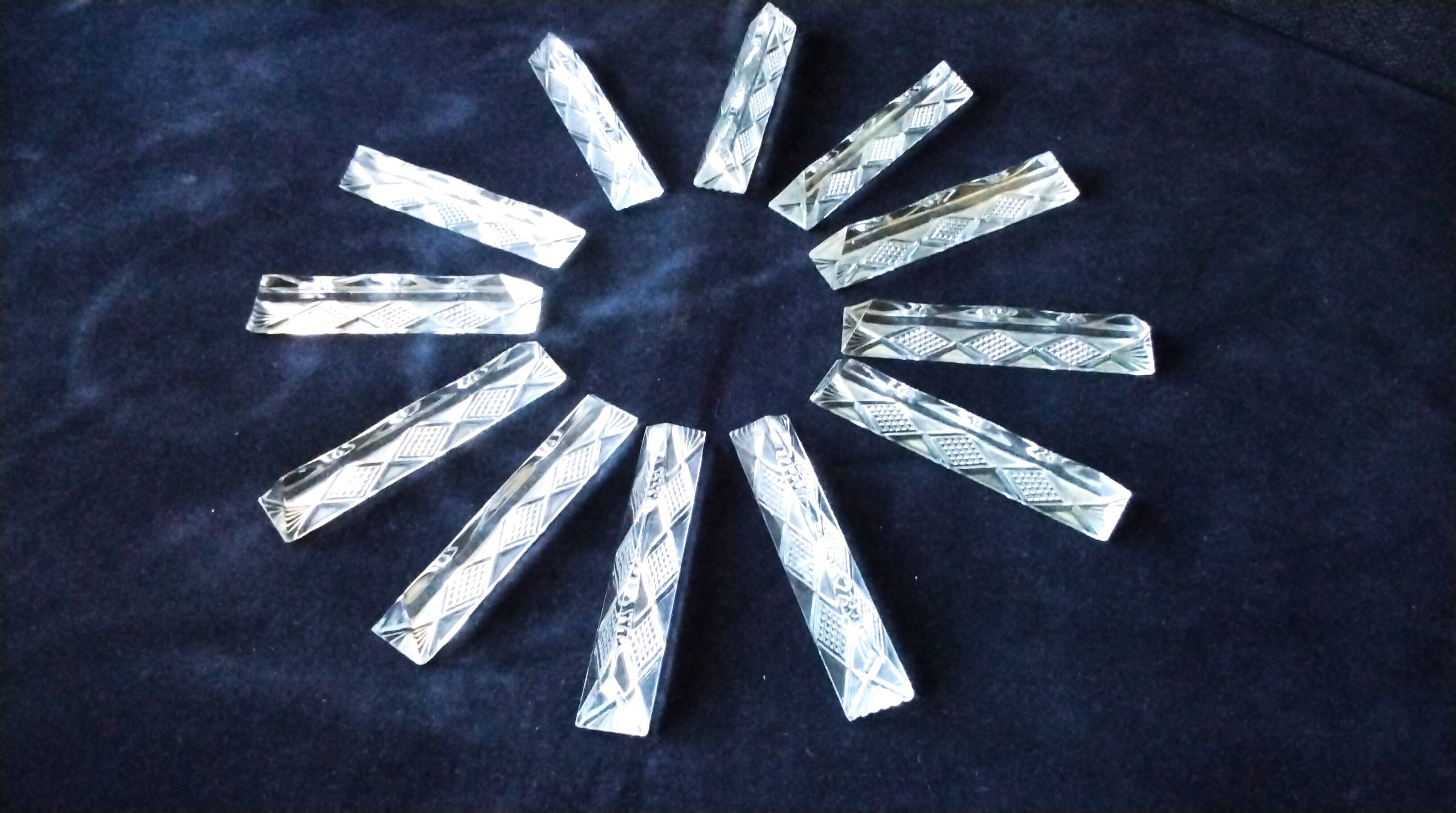 Set of 12 lead crystal knife rests in a triangular shape.