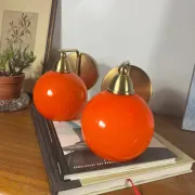 Pair of wall sconces with orange opaline glass globes and brass.