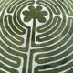 Circular rug with green decor on a cream background from the Labyrinth.