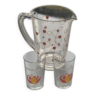 Carafe with polka dots and bubbles, red and yellow and 2 orangina advertising glasses, lemonade glass