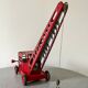 Grue de chantier rouge en tôle datant des années 60 avec mécanisme manuel