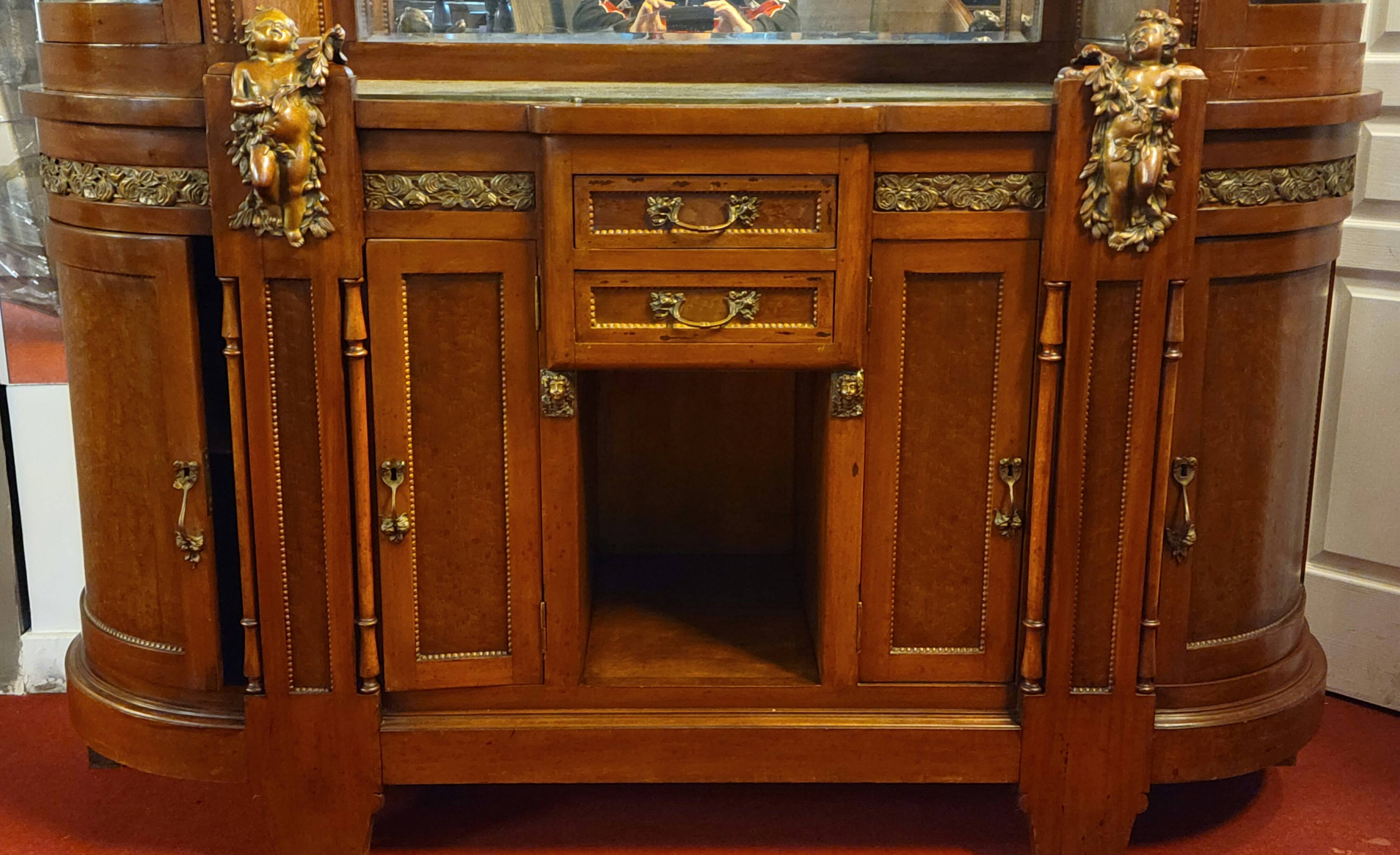 Empire style half-moon shaped mahogany bookcase with putti