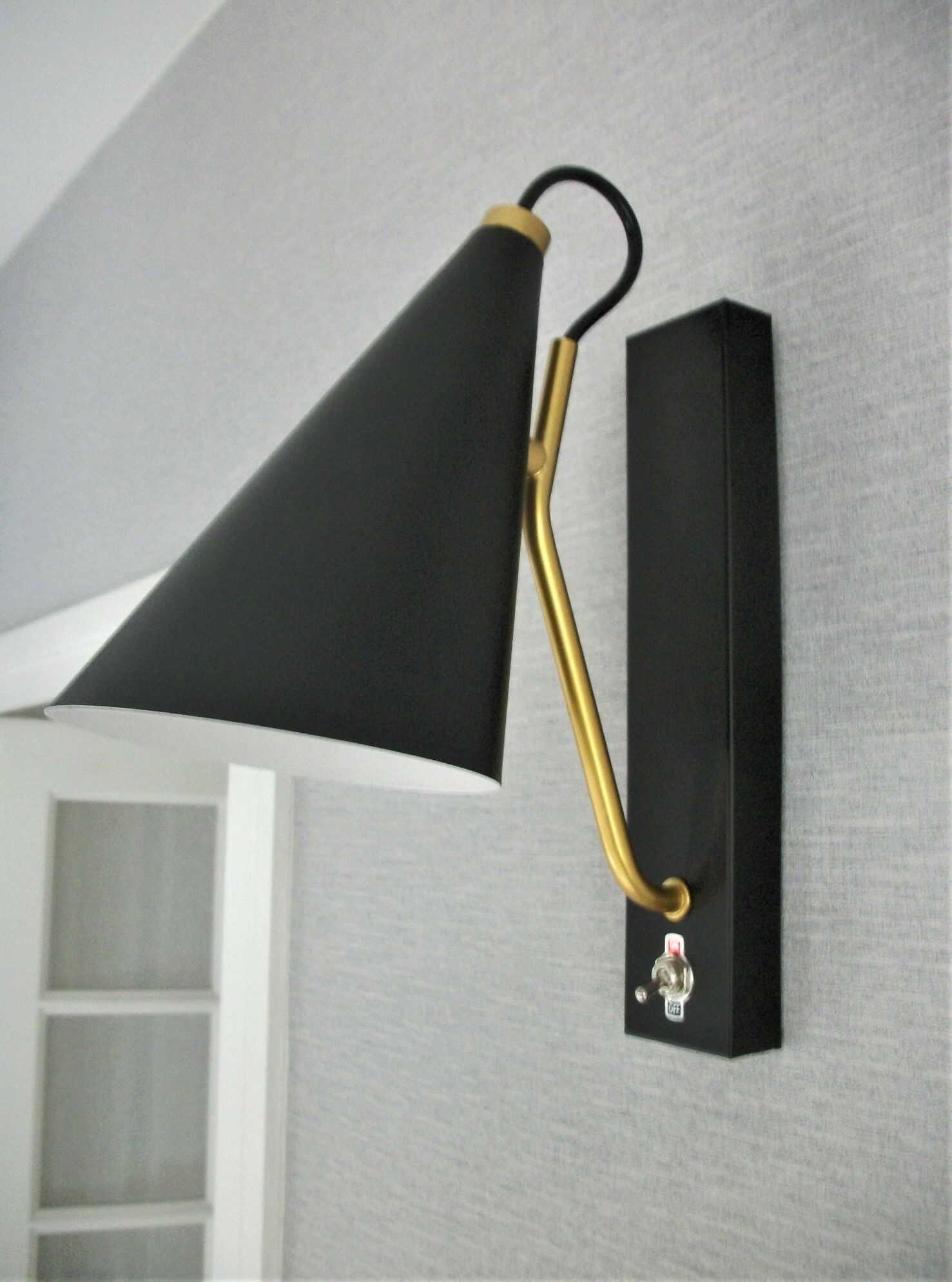 Pair of modernist sconces in black and gold metal