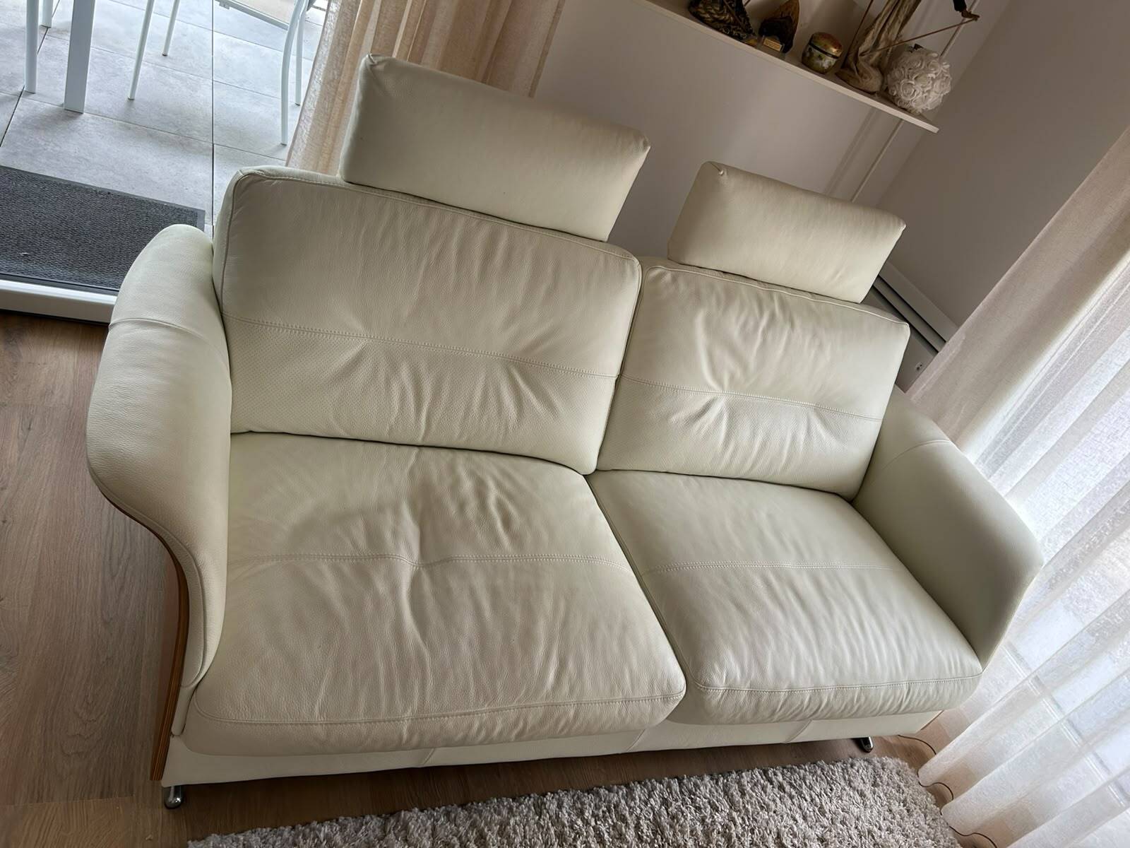 Ecru leather 2.5-seater sofa with walnut armrests.