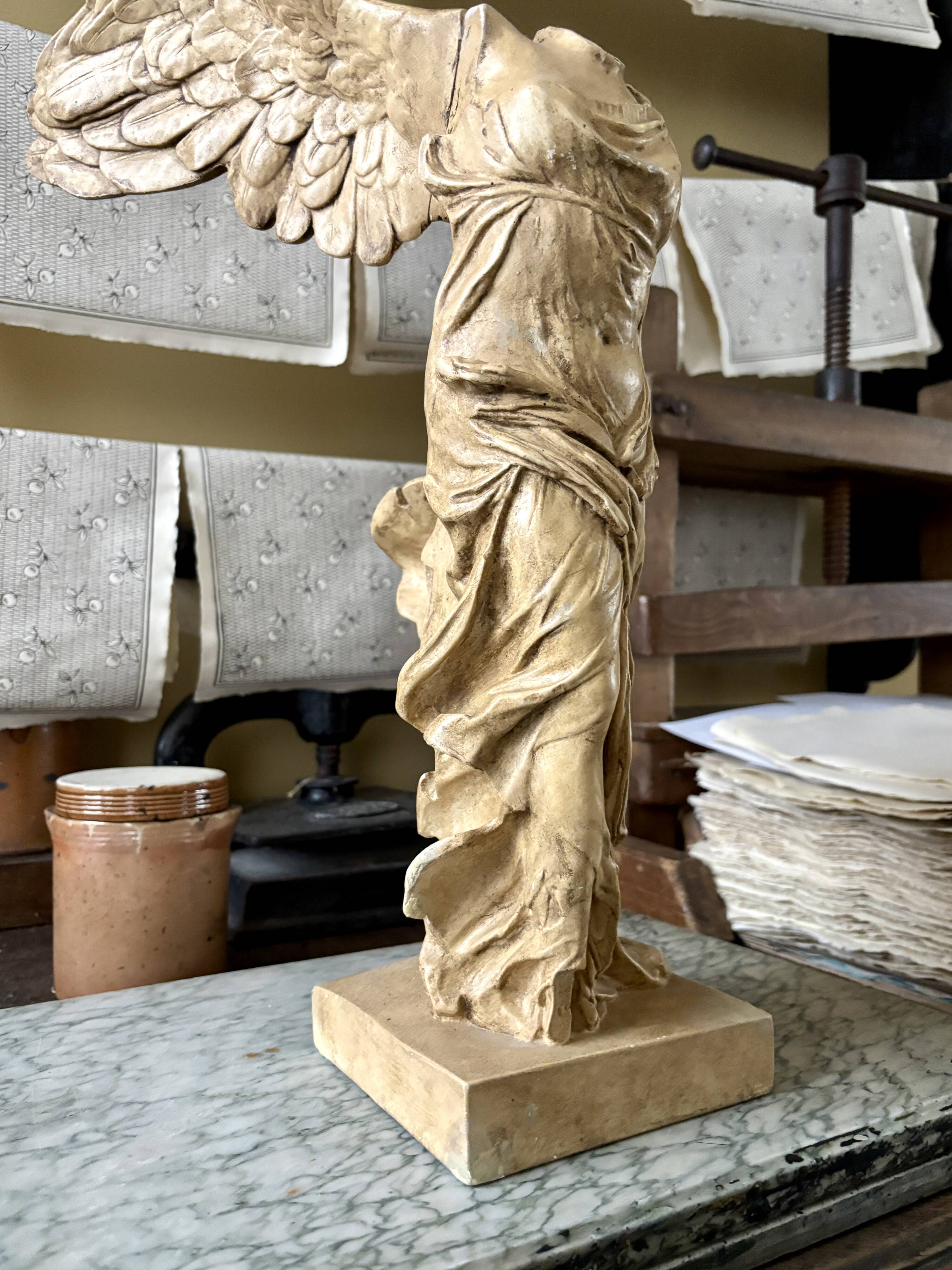 "Winged Victory of Samothrace", beige plaster statuette