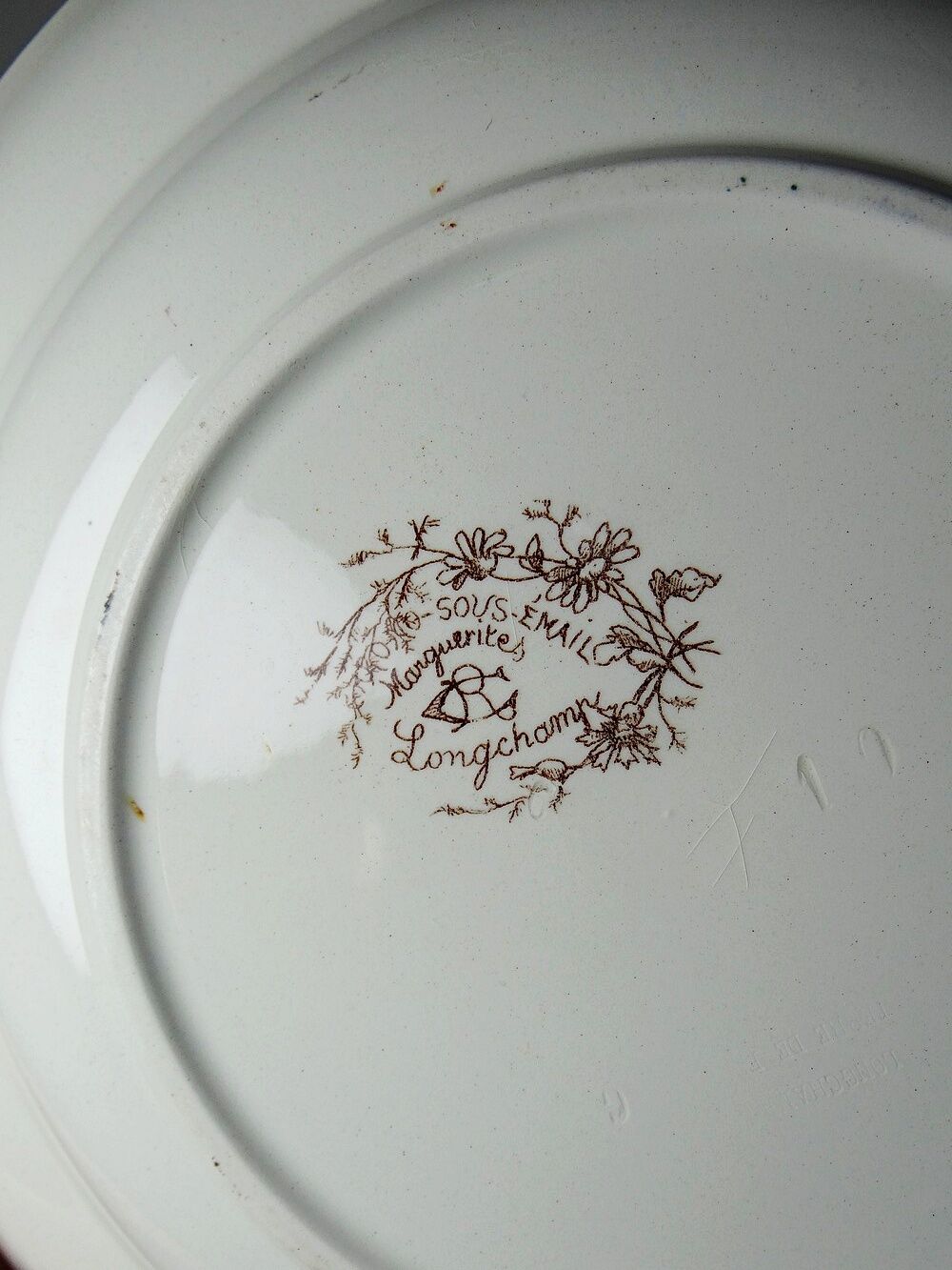 Antique Longchamp shallow dish with polychrome daisies in ironstone.