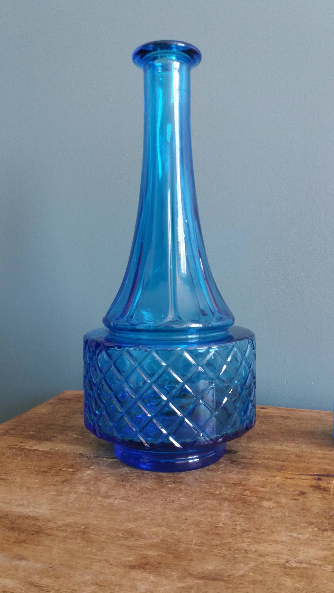Turquoise glass carafe bottle with a stopper.