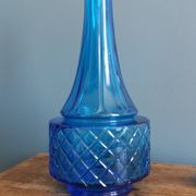 Turquoise glass carafe bottle with a stopper.