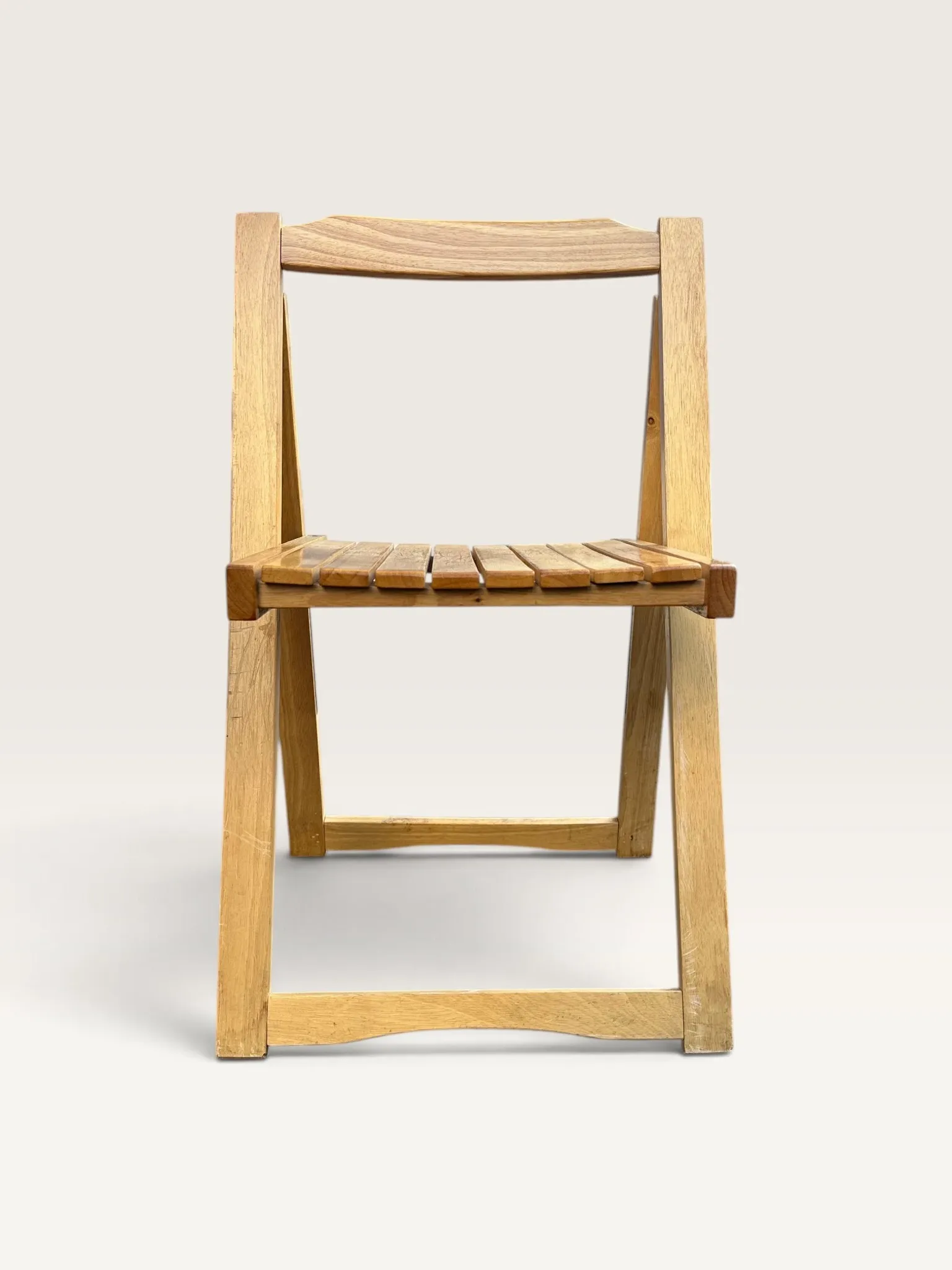 Blonde wooden folding chair in the style of Aldo Jacober.