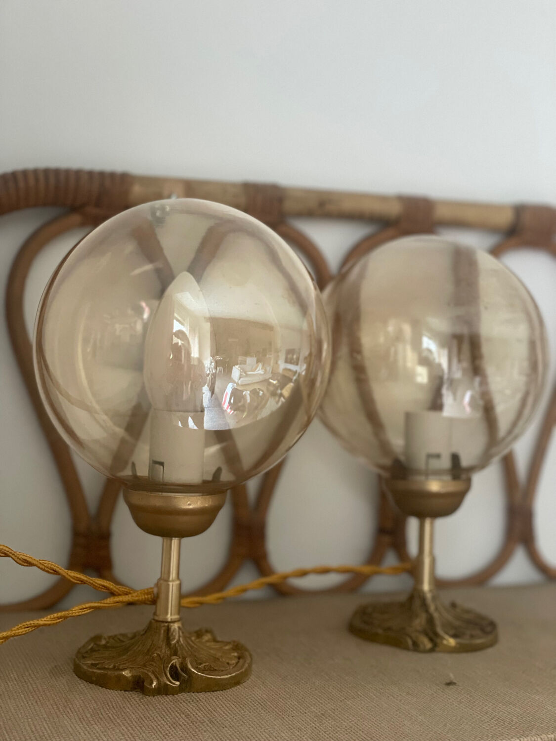 2 bedside lamps with round amber glass globes and gold metal.