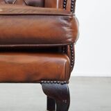 Very beautiful, stately, cowhide Chesterfield wing chair with elegant legs in a nice brown color